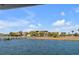 A tranquil waterfront scene featuring beautiful homes with lush landscaping along the water's edge under a bright blue sky at 1954 Sandy Point Ln, Mount Pleasant, SC 29466