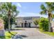 Elegant home with solar panels, framed by palm trees and a long brick driveway at 1954 Sandy Point Ln, Mount Pleasant, SC 29466