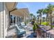 Back patio with comfortable seating overlooking manicured lawn with mature landscaping at 1954 Sandy Point Ln, Mount Pleasant, SC 29466
