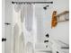 Bathroom featuring subway tile, black fixtures, wooden shelving, and a shower curtain at 2122 Commander Rd, North Charleston, SC 29405