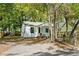 Charming single-story home boasting a fresh white exterior, cozy porch, and mature landscaping at 2122 Commander Rd, North Charleston, SC 29405