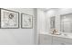 Bright bathroom featuring double sinks, white cabinetry, framed art, and coordinated fixtures at 2324 Macallan Blvd, Ravenel, SC 29470