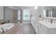 Bright bathroom featuring double vanities, walk-in shower, soaking tub and neutral colored walls and floors at 2338 Kings Gate Ln, Mount Pleasant, SC 29466