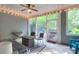Enclosed porch with string lights, comfortable seating, and views of the serene backyard at 2338 Kings Gate Ln, Mount Pleasant, SC 29466