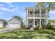 Charming two-story home with a large porch, a well-manicured lawn, and a detached garage at 2568 Hatch Dr, Johns Island, SC 29455