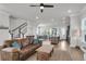 Open-concept living room with wood floors, staircase, ceiling fan, and combined kitchen/dining area at 2568 Hatch Dr, Johns Island, SC 29455