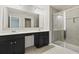 Bathroom featuring double sinks, dark cabinetry, quartz countertops, and glass-enclosed shower at 258 Godwit Dr, Summerville, SC 29486
