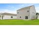 View of the back of the home with a sliding glass door and a large, well-maintained green lawn at 293 Watersglen Dr, Summerville, SC 29486
