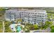 Aerial view of a gray condo building with balconies overlooking a pool and palm trees at 341 Cooper River Dr, Mount Pleasant, SC 29464