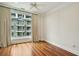 Bright bedroom featuring hardwood floors, a ceiling fan, and a large window with neighborhood views at 341 Cooper River Dr, Mount Pleasant, SC 29464