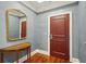 Charming hallway with a decorative table, ornate mirror, rich hardwood floors, and tasteful gray wallpaper at 341 Cooper River Dr, Mount Pleasant, SC 29464