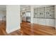 Living room with hardwood floors and built-in shelves, opening to the kitchen with stainless steel appliances at 341 Cooper River Dr, Mount Pleasant, SC 29464