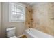 Bathtub with tiled surround and built-in shelf in a bright bathroom at 3728 Tim St, North Charleston, SC 29405