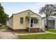 Charming yellow home featuring a cozy front porch with white railing and brick foundation at 3728 Tim St, North Charleston, SC 29405