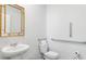 Compact bathroom featuring a pedestal sink, toilet, and grab bars for accessibility, with a gold framed mirror at 384 Willows Crescent Dr, Moncks Corner, SC 29461
