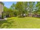 Spacious backyard features lush green grass, mature trees, and a screened porch for relaxing at 407 Burton Ave, Summerville, SC 29485