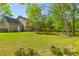 A spacious lawn and back of home shows a large grass area and tan-colored vinyl siding at 407 Burton Ave, Summerville, SC 29485