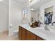 Bathroom with double sink vanity, a large mirror, wood cabinets, and ample natural light at 407 Burton Ave, Summerville, SC 29485