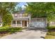 Charming two-story home with a welcoming front porch, landscaped yard, and attached two-car garage at 407 Burton Ave, Summerville, SC 29485