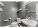 Compact half bath featuring a modern sink, toilet, decorative shelves and a gray color scheme at 407 Burton Ave, Summerville, SC 29485