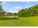 Peaceful pond view showing a well-manicured grass shoreline and tree-lined perimeter on a sunny day at 407 Burton Ave, Summerville, SC 29485