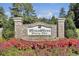 A picturesque view of a brick community sign surrounded by vibrant flowers and lush greenery at 4217 Sawgrass Dr, Charleston, SC 29420