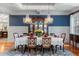Formal dining room with a crystal chandelier, wainscoting, and beautiful hardwood floors, all set for a meal at 4217 Sawgrass Dr, Charleston, SC 29420