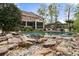 Inviting backyard pool area with rock waterfall, screened-in porch, and ample space for lounging and entertaining at 4217 Sawgrass Dr, Charleston, SC 29420