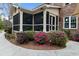 Rear exterior view of brick home featuring screened porch and tasteful landscaping at 4217 Sawgrass Dr, Charleston, SC 29420