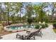 Relaxing swimming pool with lounge chairs, surrounded by lush landscaping and mature trees at 4217 Sawgrass Dr, Charleston, SC 29420