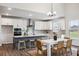 Bright kitchen featuring white cabinetry, stainless steel appliances, an island with seating, and an adjacent dining area at 457 White Magnolia St, Moncks Corner, SC 29461