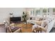 Cozy living room with a comfortable sofa, two armchairs, a glass coffee table, and natural lighting from the windows at 457 White Magnolia St, Moncks Corner, SC 29461
