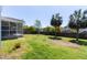 A green backyard with a screened-in porch, grass and trees at 5007 Ballantine Dr, Summerville, SC 29485