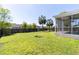 A green backyard with a screened-in porch, grass and trees at 5007 Ballantine Dr, Summerville, SC 29485