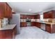 A spacious kitchen with dark wood cabinets, stainless steel appliances, and bright marble pattern flooring at 5007 Ballantine Dr, Summerville, SC 29485