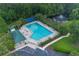 Aerial view of a community pool, tennis court, and pond surrounded by lush green trees at 5007 Ballantine Dr, Summerville, SC 29485