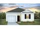 Charming single-story home featuring white siding, a gray roof, and an attached garage, set against a beautiful sky at sunset at 7027 Deanston Dr, Ravenel, SC 29470