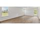 Spacious living room featuring wood-look flooring, large windows, and a glass door, offering plenty of natural light at 7027 Deanston Dr, Ravenel, SC 29470