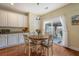 Bright dining area with white chairs, hardwood floors, and view of a covered outdoor patio area at 708 Professor Dr, Ladson, SC 29456