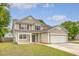 Charming two-story home with vinyl siding, a two-car garage, and a welcoming front porch with a decorative wreath at 708 Professor Dr, Ladson, SC 29456