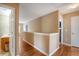 View of the upstairs landing with wood floors and half wall separating the hallway from another bedroom at 708 Professor Dr, Ladson, SC 29456