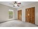 Bright bedroom features neutral carpet, a ceiling fan, and double closet at 7920 Parklane Ct # 608, North Charleston, SC 29418