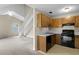 Open-concept living area with view of the functional kitchen featuring wood cabinets, a black range, and a dishwasher at 7920 Parklane Ct # 608, North Charleston, SC 29418