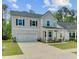 Charming two-story home boasts a two-car garage, covered porch, and beautifully landscaped front yard at 86 Red Bluff St, Summerville, SC 29483