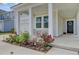 Inviting front porch with seating area and colorful landscaping, leading to a black front door at 86 Red Bluff St, Summerville, SC 29483