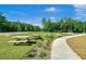 Community picnic area with wooden picnic tables and benches on a sunny green lawn at 86 Red Bluff St, Summerville, SC 29483