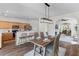 Open dining area flowing into the kitchen, featuring a rustic table, bar seating, and modern lighting at 8961 N Red Maple Cir, Summerville, SC 29485