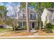 Charming two-story home featuring neutral siding, black shutters, a manicured lawn, and mature trees at 8961 N Red Maple Cir, Summerville, SC 29485
