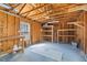 Unfinished garage interior with exposed wood framing, storage shelves, and natural light from a window at 8961 N Red Maple Cir, Summerville, SC 29485