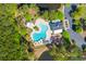 Aerial view of a community pool surrounded by trees, with parking, a pool house, and lounge areas at 8961 N Red Maple Cir, Summerville, SC 29485